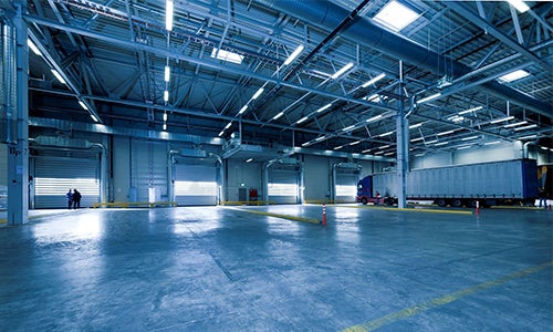 A shipping warehouse with an eighteen wheeler inside.