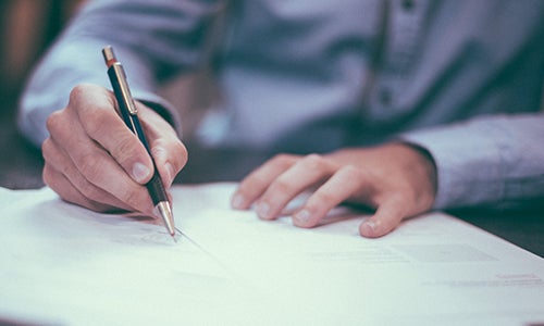 A person signs paperwork