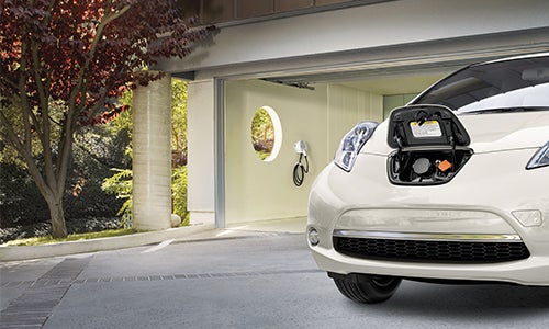 An electric car sits in a driveway