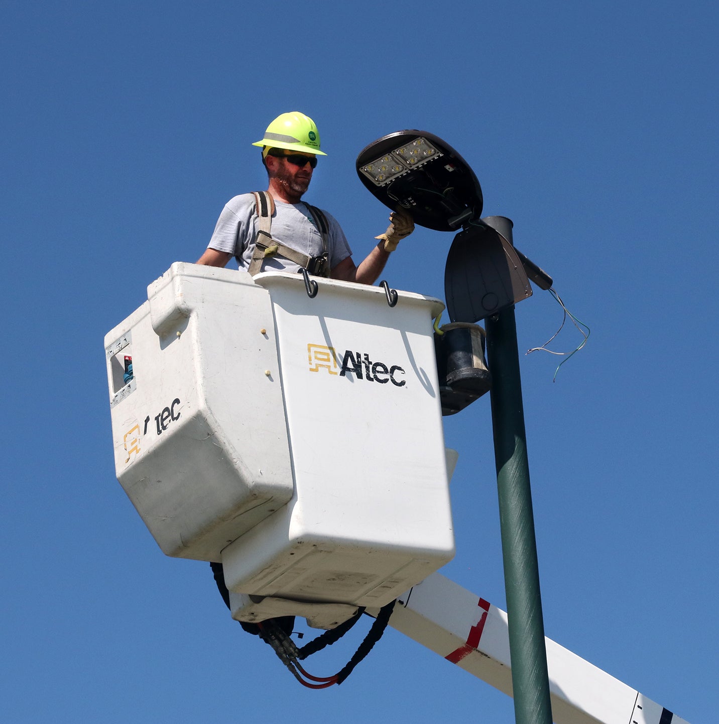 A CREC lineman replaces a parking lot light