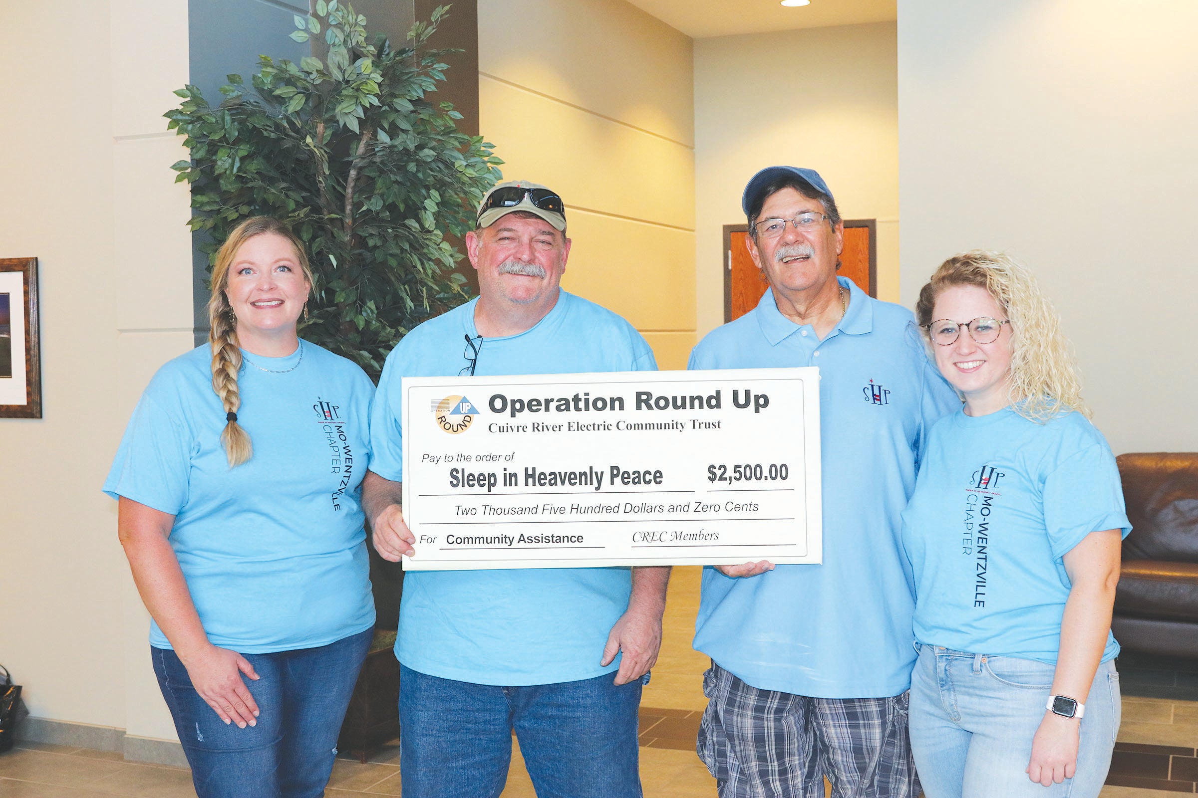 Representatives from Sleep in Heavenly Peace Wentzville pose with a $2,500 check from Operation Round Up