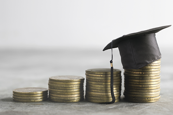 a stack of coins with a graduation cap